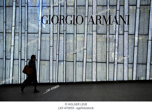 Woman walking in front of Giorgio Armani storefront, Central, Hong Kong Island, Hong Kong