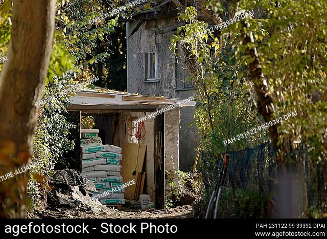 22 November 2023, Berlin: Building materials lie under a roof on the grounds of a house where the outer wall has collapsed