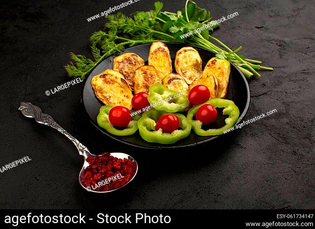 a top view vegetables sliced colorful such as green bell pepper with greens on the dark floor