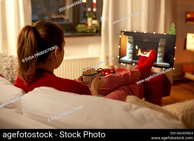 woman watching tv with cream and marshmallow on christmas
