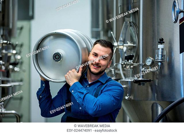 Portrait of brewer carrying keg