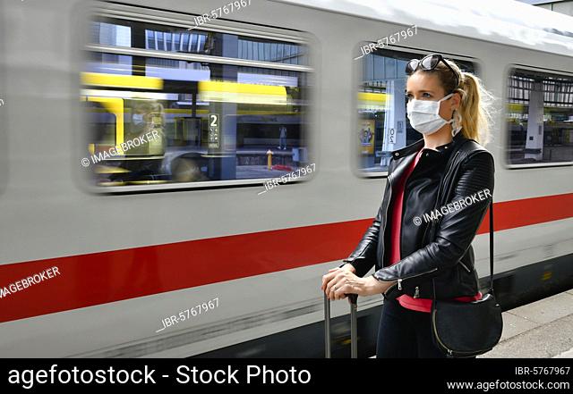 Woman with face mask, waiting for train, corona crisis, main station, Stuttgart, Baden-Württemberg, Germany, Europe
