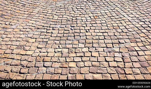 Stone pavement in perspective. Stone pavement texture. Granite cobblestoned pavement background. Abstract background of a cobblestone pavement close-up