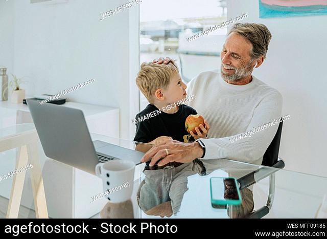 Happy father with son sitting at table