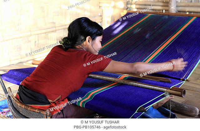 A Marma tribal woman weaving cloth on traditional handloom Bandarban, Bangladesh December 2009