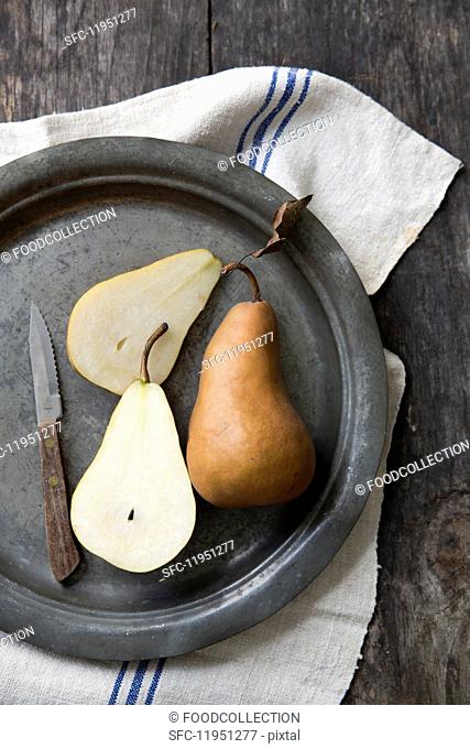 Boskop pears, whole and halved, on a pewter plate