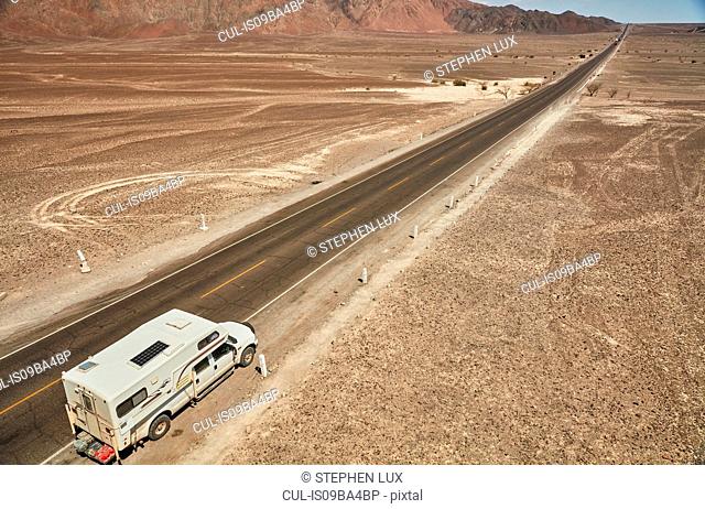 High angle view of campervan parked on desert roadside, Hacienda Ventilla, Ica, Peru