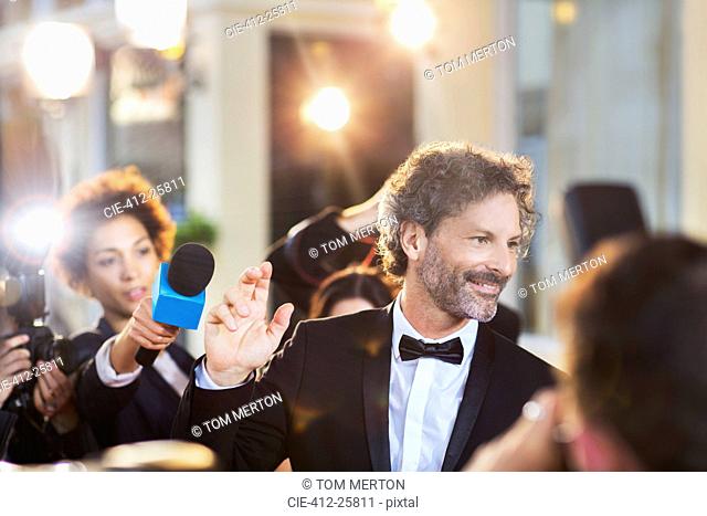 Celebrity waving to paparazzi at event