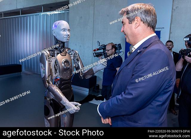 20 May 2022, Bavaria, Nuremberg: Markus Söder (CSU), Minister President of Bavaria, stands next to the humanoid robot AMECA from the manufacturer Engineered...