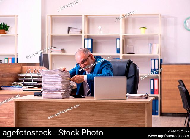 Old male employee unhappy with excessive work at workplace