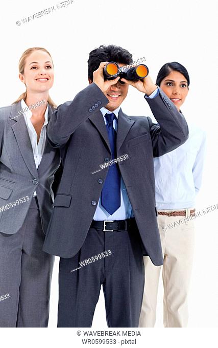 Businessman looking up through binoculars with two smiling girls behind him