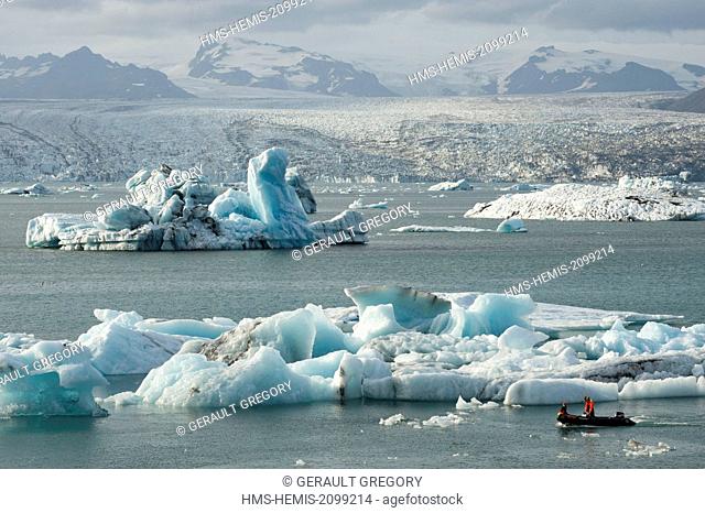 Iceland, Austurland, Jokulsarlon, Vatnajokull National Park, zodiac carrying tourists on the lagoon filled with icebergs