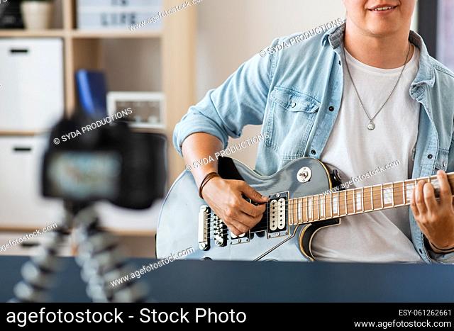 man with camera playing guitar and recording video