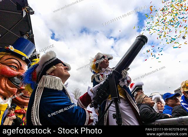 11 November 2023, Rhineland-Palatinate, Mainz: Guardsmen fire a confetti cannon. Traditionally, the ""foolish basic laws"" with their eleven articles for the...