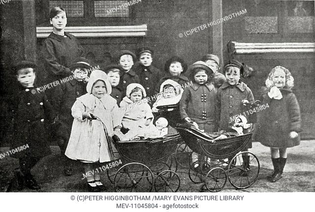 Girls at Headingley Orphan Homes, Leeds, prepare for a walk with dolls in toy prams