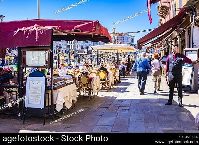 Tables on the terraces in the lively Riva del Vin street. Grand Canal. Venice, Veneto, Italy, Europe