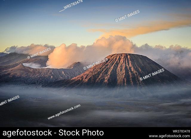 Mount Bromo volcano, a somma volcano and part of the Tengger mountains range, the cone rising above mist in the landscape