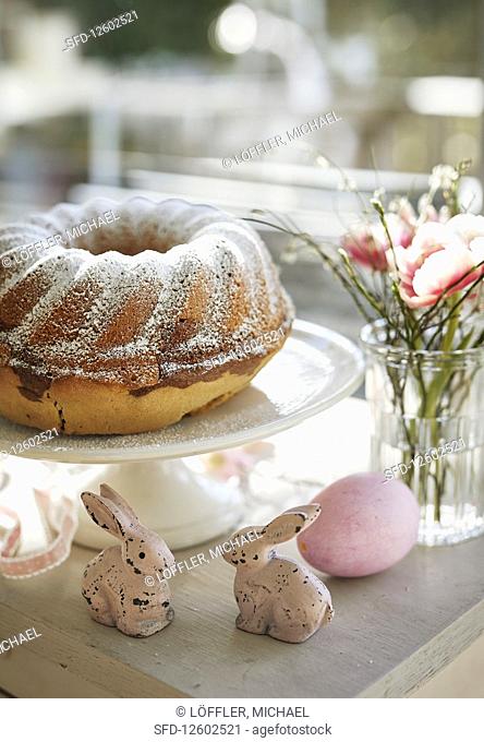 A Bundt cake decorated with eggs, bunnies and flowers for Easter