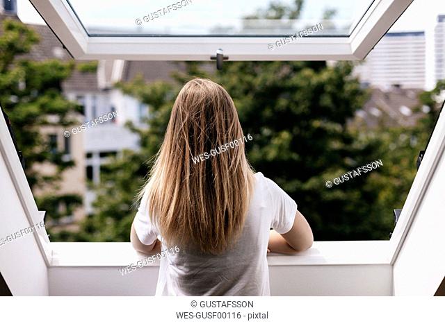 Young woman looking out of window