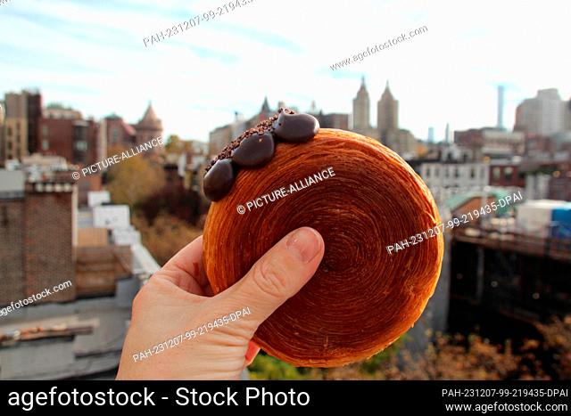 17 November 2023, USA, New York: A woman holds a ""suprême"" - a kind of croissant filled with chocolate cream. (to dpa-KORR ""Ten years ago