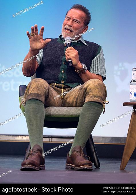 25 September 2022, Bavaria, Munich: Arnold Schwarzenegger, actor and former governor of California, sits on stage at the Bits & Pretzels company founder and...