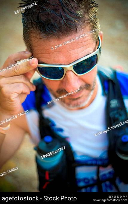 Photography session of trail runner runnig in the middle of nature and in the mountains. Preparing and interviewing