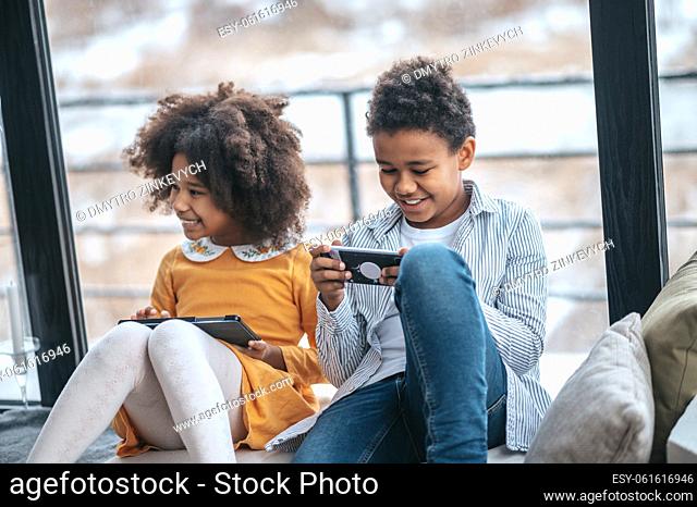 On internet. Two kids spending time online using their devices