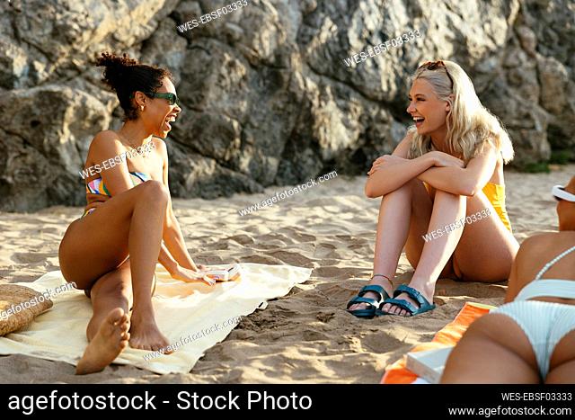 Friends laughing and relaxing at beach