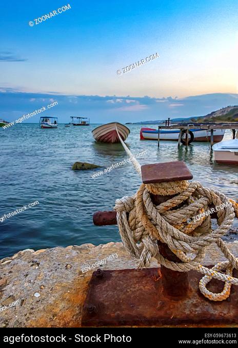 Amazing long exposure landscape at rope anchoring fishing boat at the pier