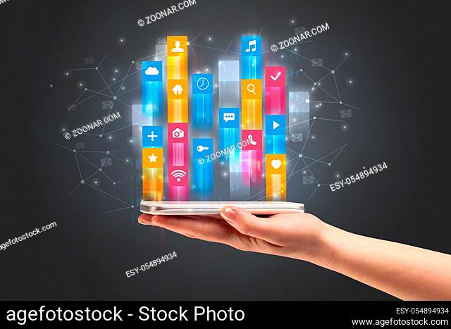 Businessman hand using phone with flying application icons around