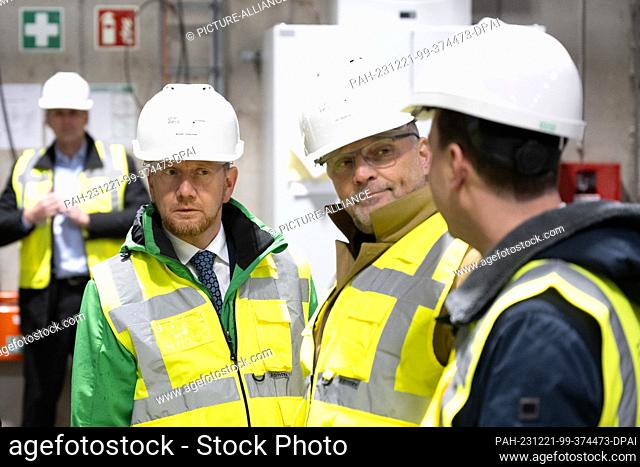 21 December 2023, Saxony, Freiberg: Michael Kretschmer (CDU, l), Minister President of Saxony, takes part in a tour of the new Plant II of recycling company...