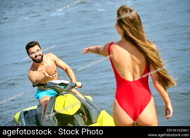 On a scooter. A young couple in swimming suits on a water scooter