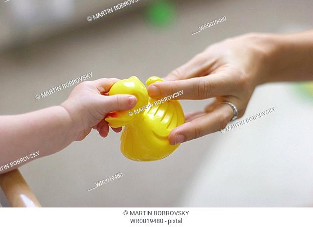 baby grabbing yellow rubber duck