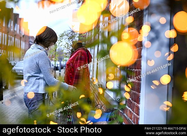 21 December 2021, Brandenburg, Potsdam: Outside a women's fashion store in the Dutch Quarter, some clothing is also displayed for customers to see while...