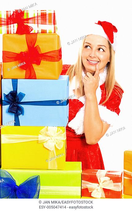 Young blond happy cute woman in Santa costume surrounded by Christmas gift boxes, isolated on white background
