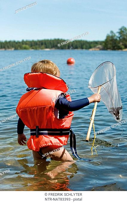 A boy with a bag net, Stockholm archipelago, Sweden