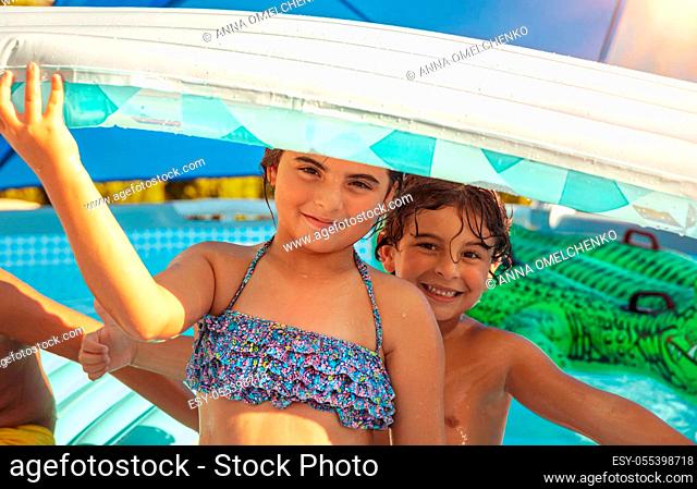 Two Cheerful Kids with Inflatable Mattress in the Pool. Having Fun Together. Happy Holidays in the Summer Camp