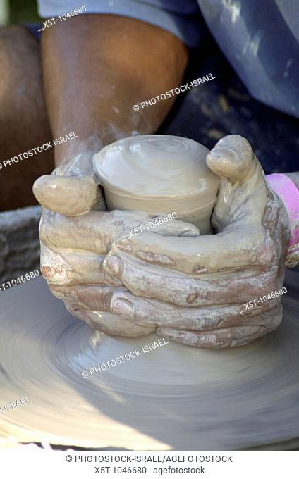 Man making a clay pot on a potters wheel