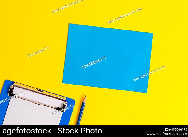Clipboard holding blank paper sheet square page pencil colored background