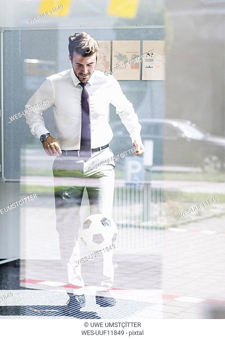 Businessman playing football in office