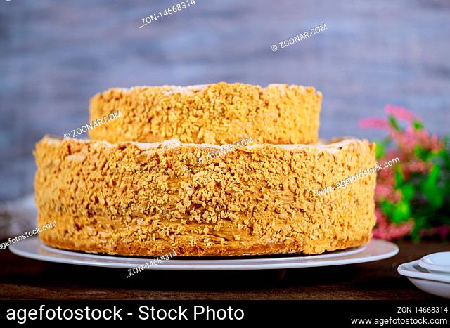 Cake Napoleon with flowers and white plates and fork