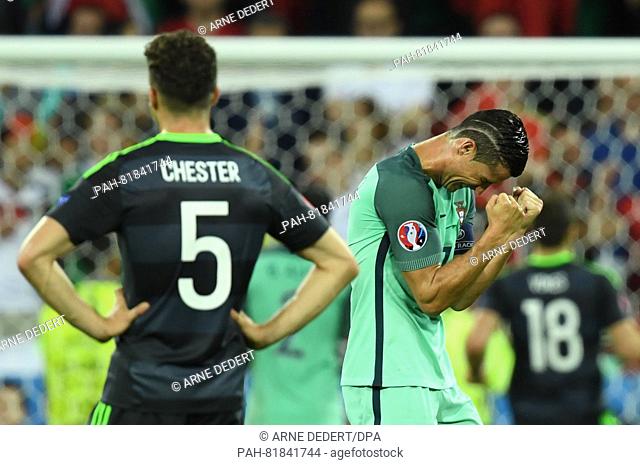 Cristiano Ronaldo (R) of Portugal celebrates next to James Chester of Wales during the UEFA EURO 2016 semi final soccer match between Portugal and Wales at the...