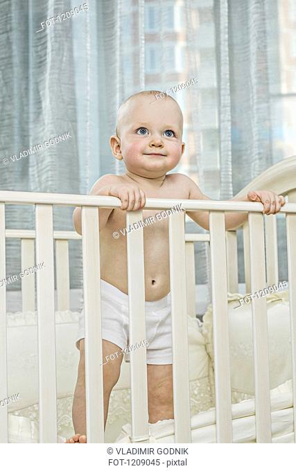 Baby standing up in cot