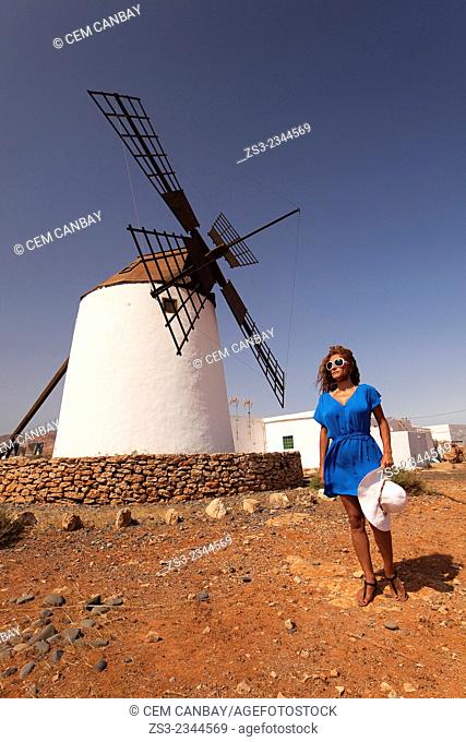 Woman posing in front of the windmill near Antigua, Fuerteventura, Canary Islands, Spain, Europe