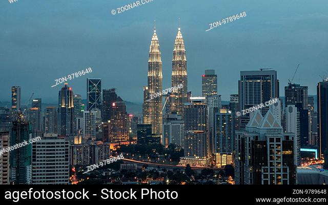 Evening cityscape with illumination of building including Petronas Twin Towers. Kuala Lumpur, Malaysia