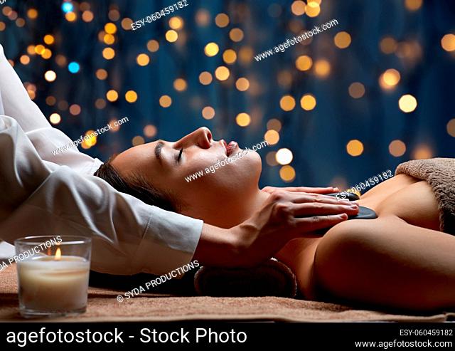 close up of woman having hot stone massage at spa