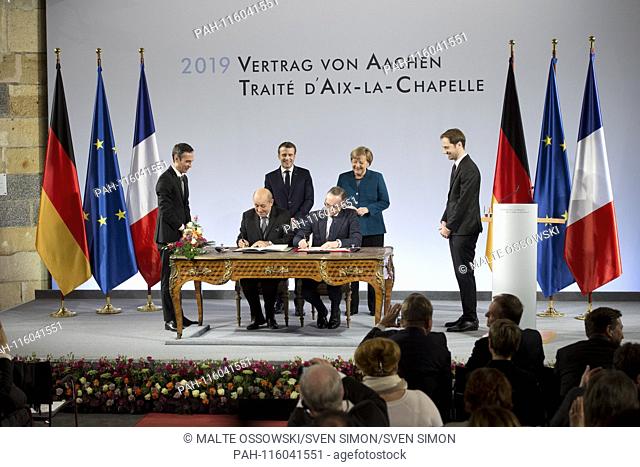 Emmanuel MACRON, President of the French Republic, and with Chancellor Angela MERKEL, sign the treaty, with French Foreign Minister Jean-Yves Le Drian and...