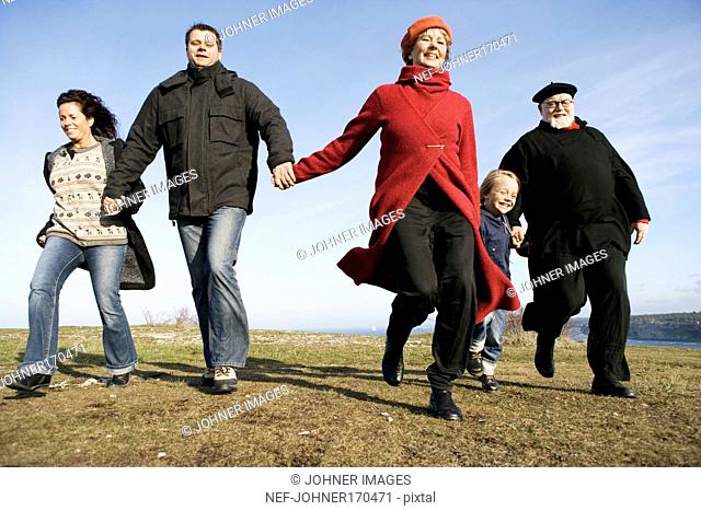 Five people running hand in hand