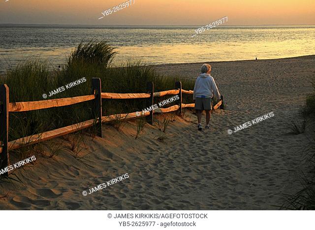 An Elderly woman follows a path to the sea in Cape May New Jersey the very southern tip of the state