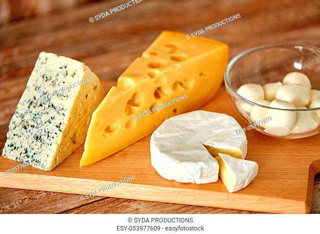 different kinds of cheese on wooden cutting board